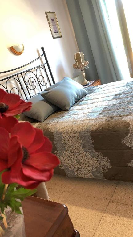 a bedroom with a bed and a vase with red flowers at Two Flowers Hotel in Pedoulas