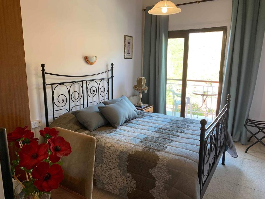 a bedroom with a bed with red flowers on it at Two Flowers Hotel in Pedoulas