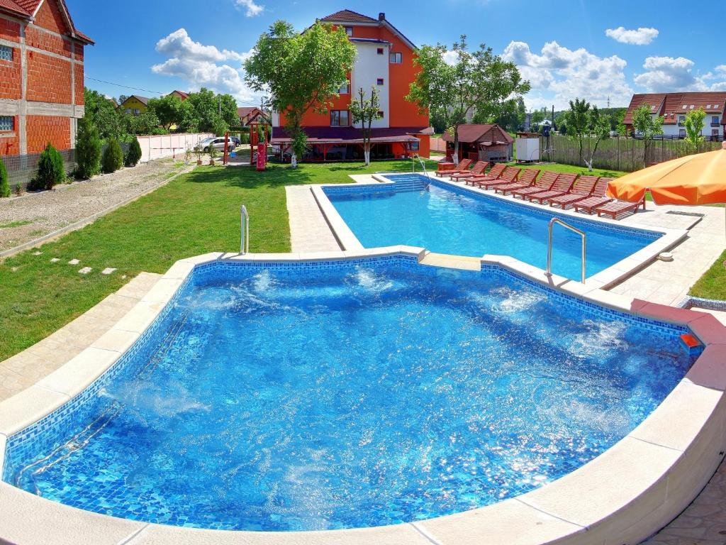 una gran piscina con sillas alrededor en Pensiunea Casa Porojan, en Baile 1 Mai