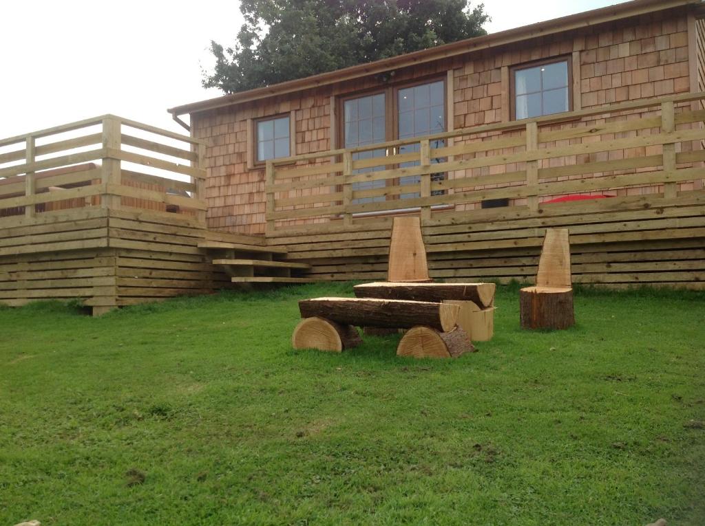 una casa de madera con un banco delante en Orme View Lodges en Bangor
