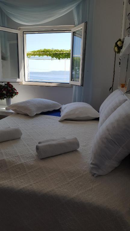a large bed with pillows on it with a window at Apartment BIM in Pisak