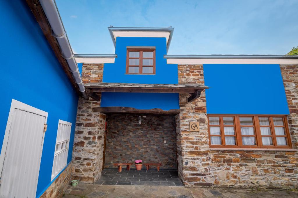 una casa azul con una mesa de picnic en el patio en Casa de Aldea el Ferreirón, en Castropol