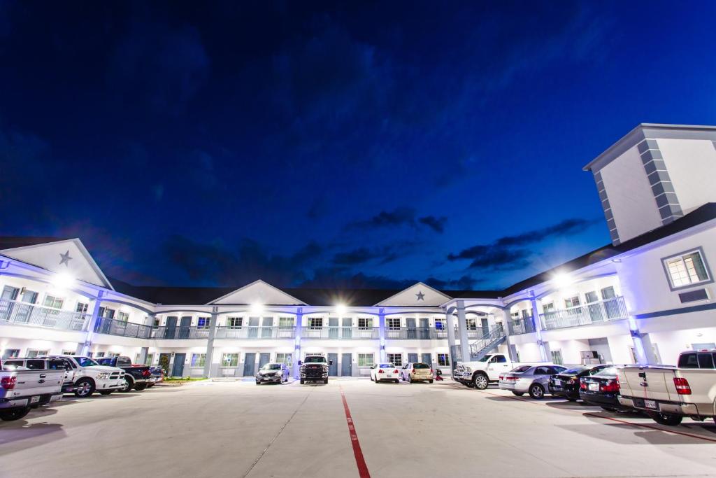 a large building with cars parked in a parking lot at Palace Inn- Louetta in Spring