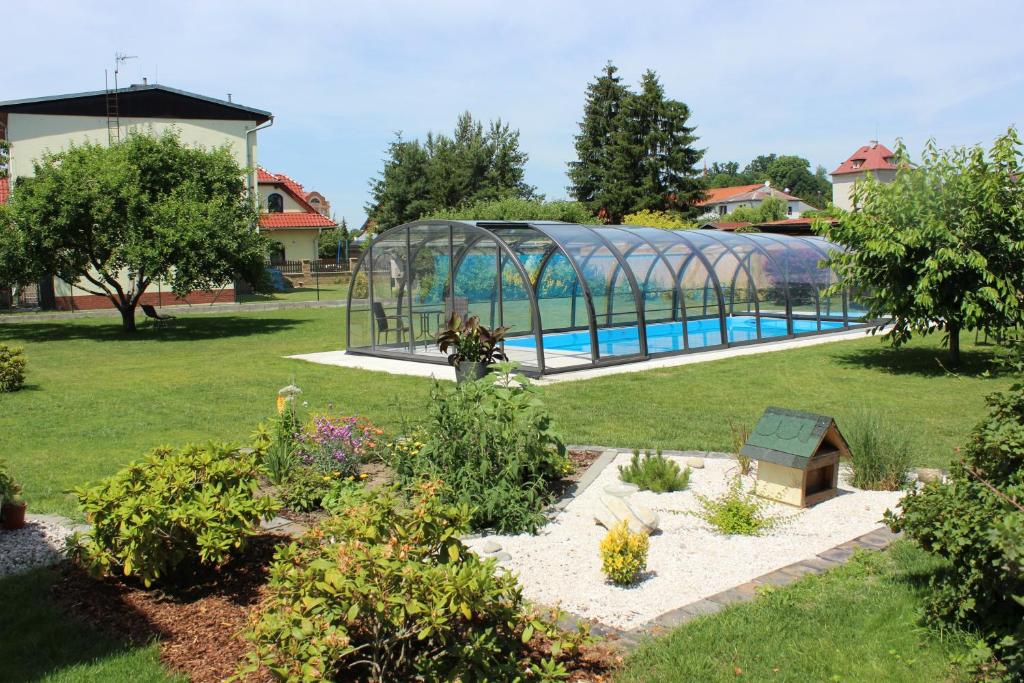 einen Garten mit Pool und Gewächshaus in der Unterkunft Apartment Dream in Franzensbad