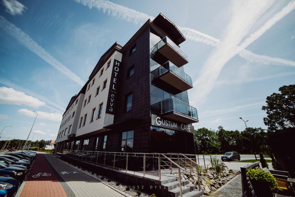 un bâtiment noir avec une voiture garée dans un parking dans l'établissement Hotel Evva, à Tarnobrzeg