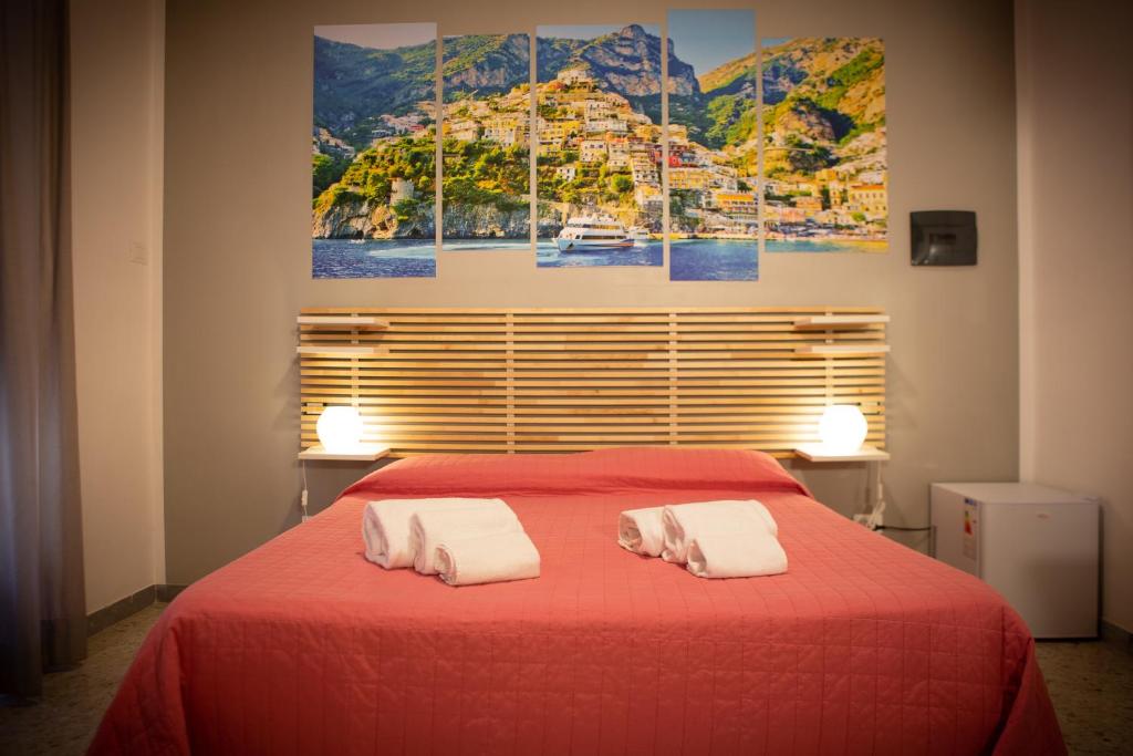 ein Schlafzimmer mit einem roten Bett und zwei weißen Handtüchern in der Unterkunft B&B Salerno Center in Salerno