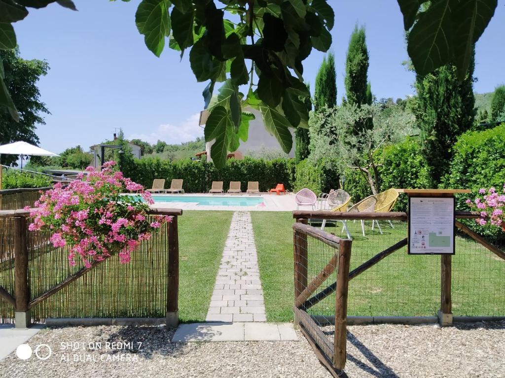 een tuin met een hek en een zwembad bij Agriturismo Fattoria Podere Peciano in Cortona