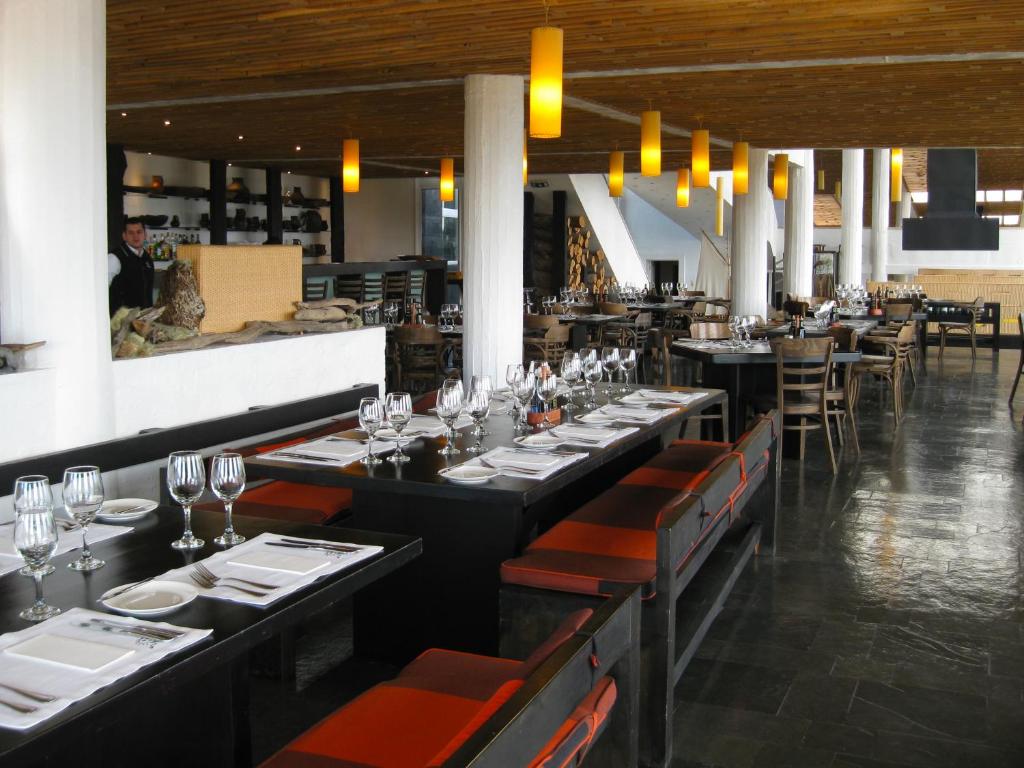 a dining room with long tables and chairs with wine glasses at Remota Patagonia Lodge in Puerto Natales