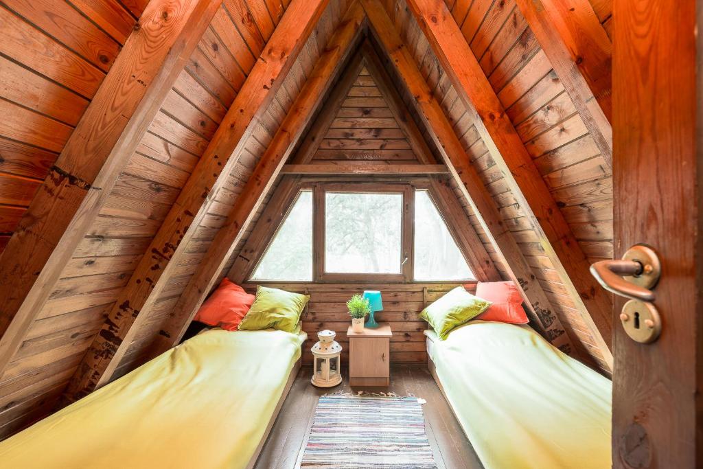 2 Betten in einem Zimmer in einem Baumhaus in der Unterkunft Domki jak PRLu w Camp LIPNO in Stęszew