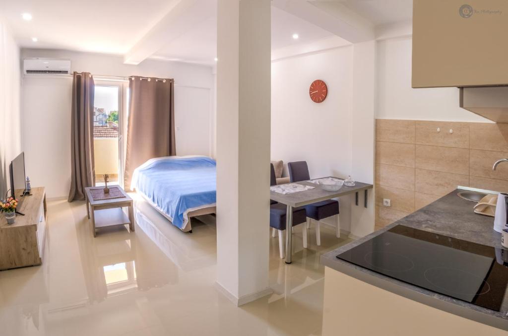 eine Küche und ein Schlafzimmer mit einem Bett und einem Tisch in der Unterkunft Apartmani Kankaras - Sea View in Tivat