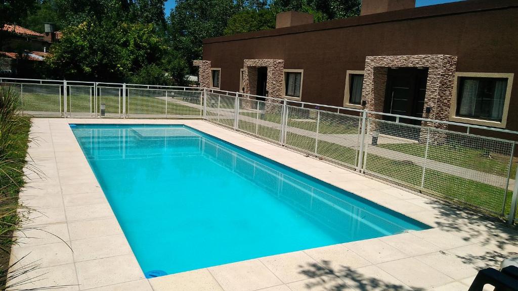 una gran piscina azul junto a un edificio en Merlo Centro Aparts en Merlo