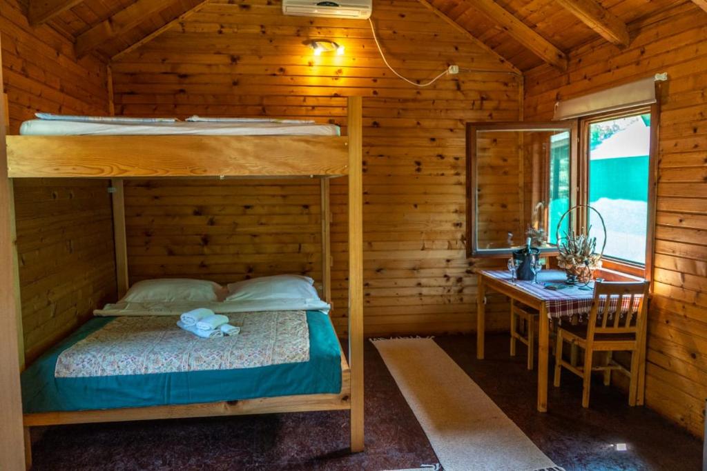 PonariにあるWooden Village Resortのベッドルーム1室(二段ベッド1組、テーブル、デスク付)