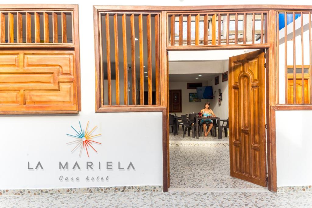 a door to a cafe house with a woman in the background at Casa Hotel La Mariela in Zapzurro
