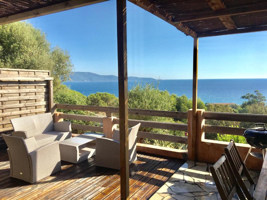 een terras met stoelen en uitzicht op de oceaan bij Residence du valinco Appartement in Olmeto