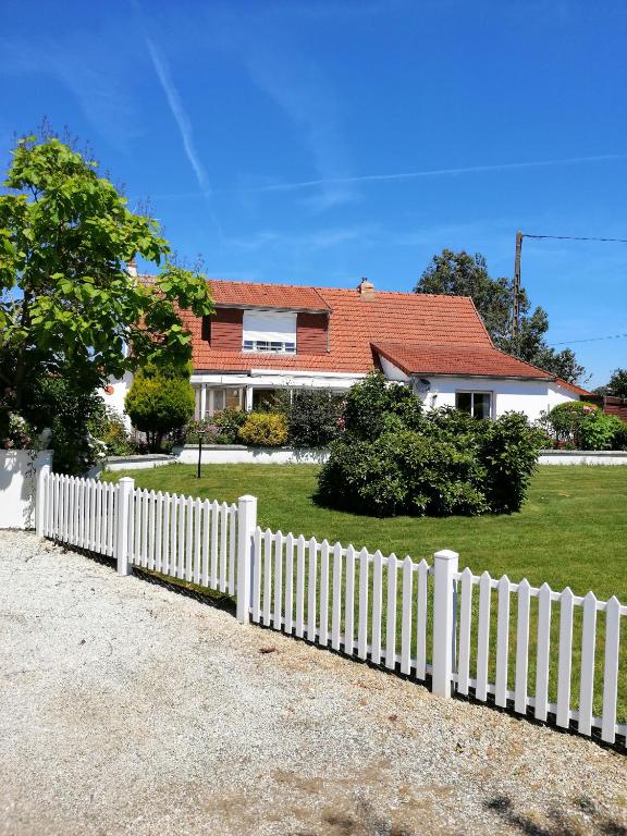 une clôture blanche devant une maison dans l'établissement La Porte, Rose View Gite, à Courson