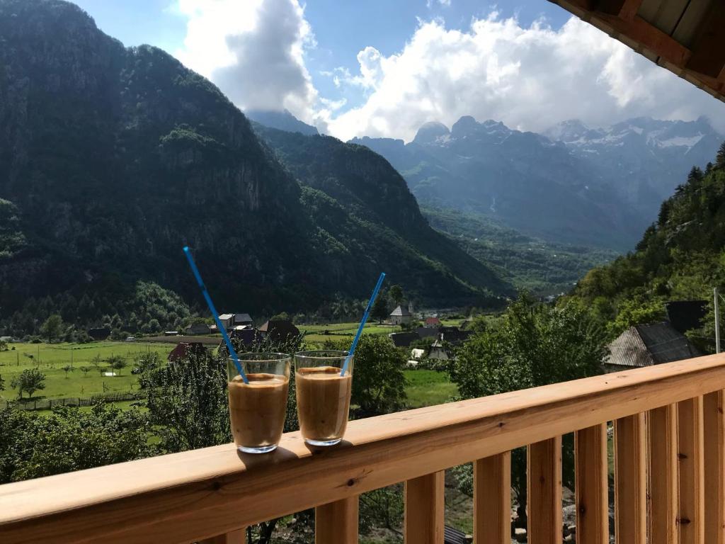 Duas bebidas numa varanda com vista para as montanhas em Bujtina Ziçi em Theth