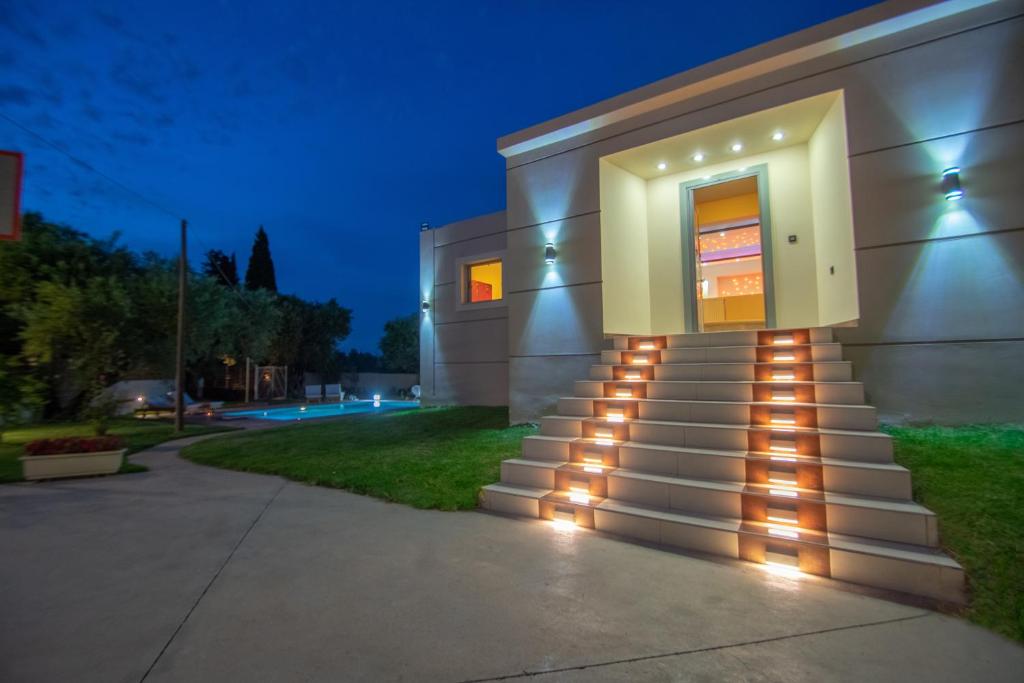 a building with a staircase with lights on it at Zante Lagos holiday homes Treehouse and Villa in Vouyiáton