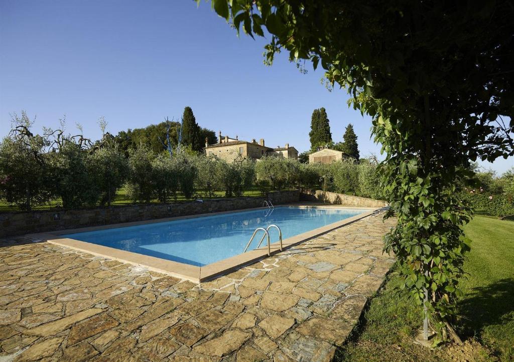 - une piscine dans une cour avec une maison en arrière-plan dans l'établissement Castellare de Sernigi, à Marcialla