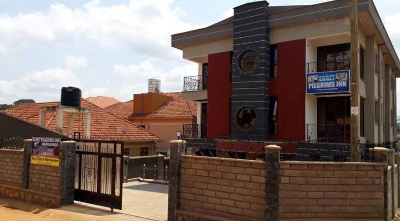 een gebouw met een hek ervoor bij Egret Pilgrims Inn in Kampala