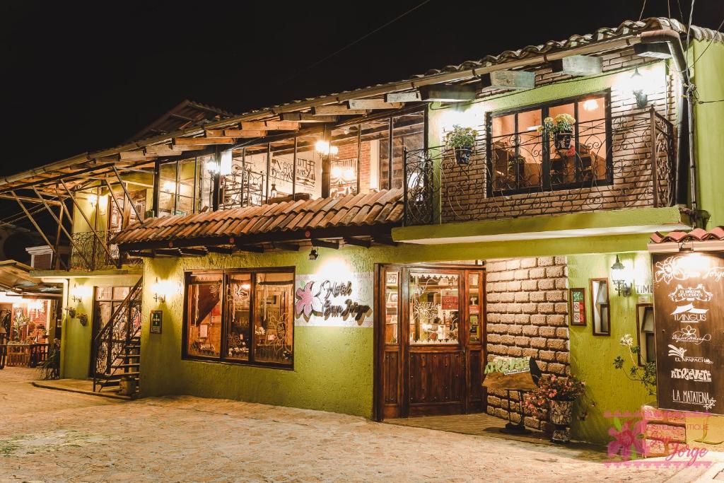 a green building with windows and doors at night at Hotel San Jorge in Tlatlauquitepec