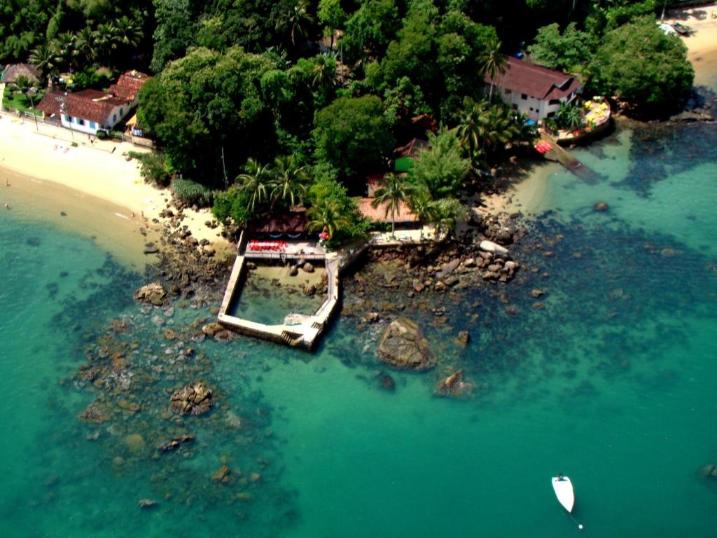 una vista aérea de una playa con un barco en el agua en Aquario Pousada Hostel - Night Club, en Abraão