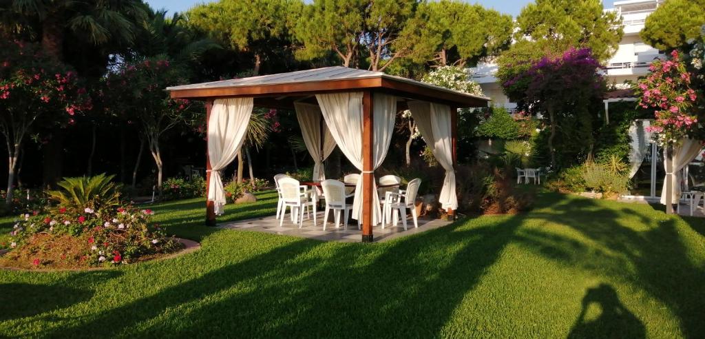 a gazebo with a table and chairs in a yard at Ballos Apartments in Nea Makri