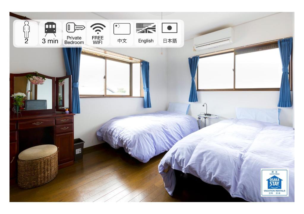 sypialnia z 2 łóżkami i komodą oraz 2 oknami w obiekcie A&Z Guest House w mieście Kaizuka
