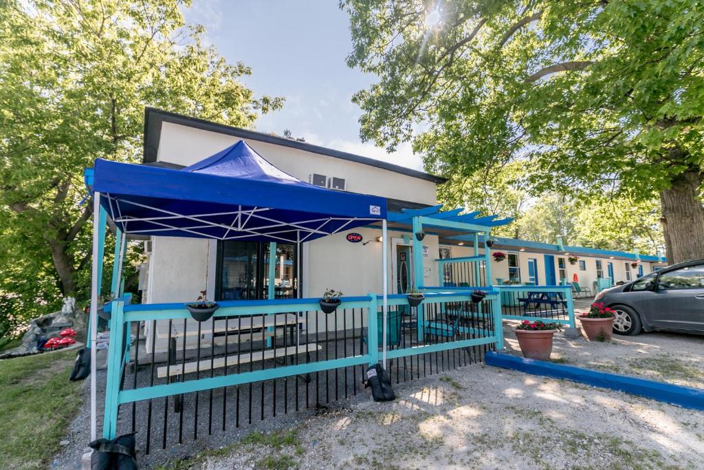 a house with a blue canopy in front of it at Beachfront at Beach1 Motel in Wasaga Beach