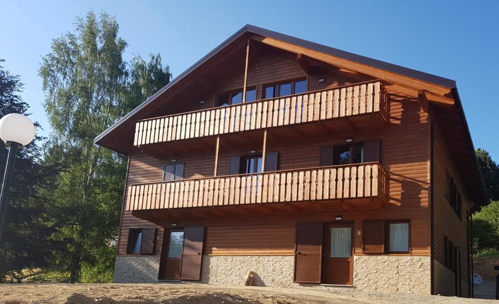 a large wooden building with a balcony on top at Lorica Suite Lago in Lorica