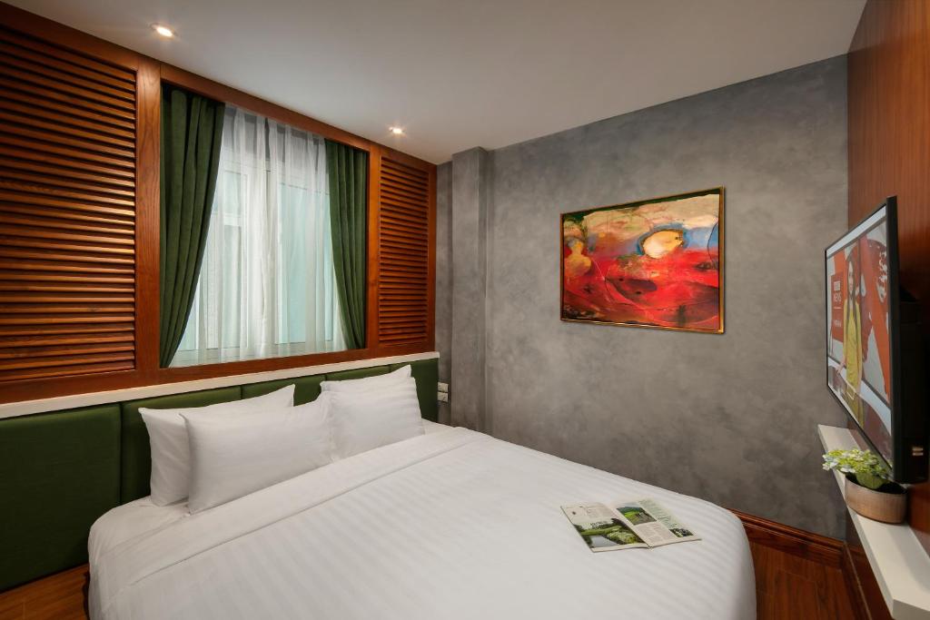 Postel nebo postele na pokoji v ubytování Hanoi La Selva Central Hotel & Spa