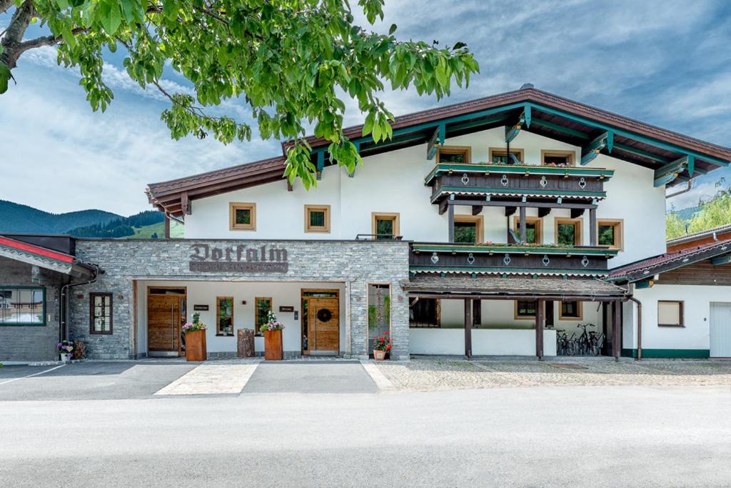a large white building with a lot of windows at Pension Restaurant Dorfalm in Leogang