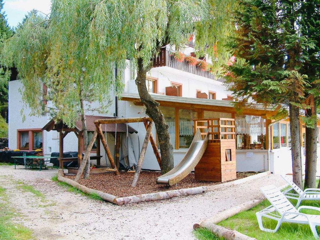 a playground in front of a house with a slide at Laugen Cafè, Pizza, B&B in San Felice