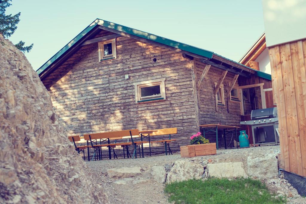 ein Blockhaus mit einem Tisch und Bänken davor in der Unterkunft JoSchi Almhütte Hochkar in Göstling an der Ybbs