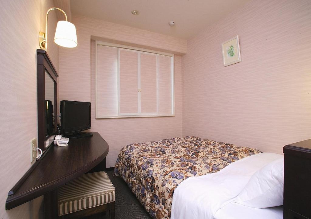 Postel nebo postele na pokoji v ubytování Hamamatsu Hotel