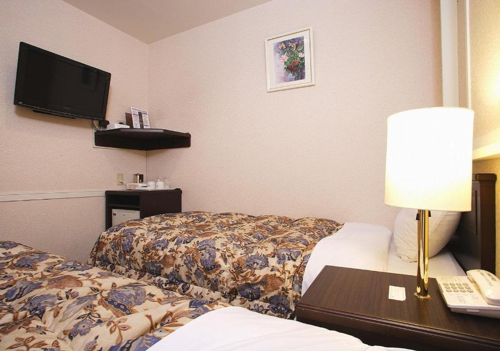 Postel nebo postele na pokoji v ubytování Hamamatsu Hotel