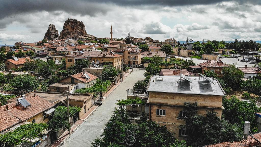uma cidade com edifícios e uma montanha ao fundo em Capiedra Hotel em Üçhisar