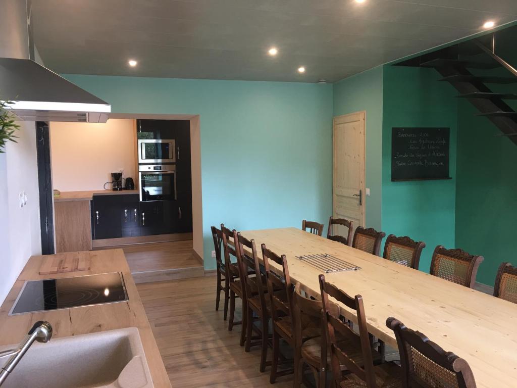 a dining room with a long table and chairs at Le petit verger in Dompierre-les-Tilleuls