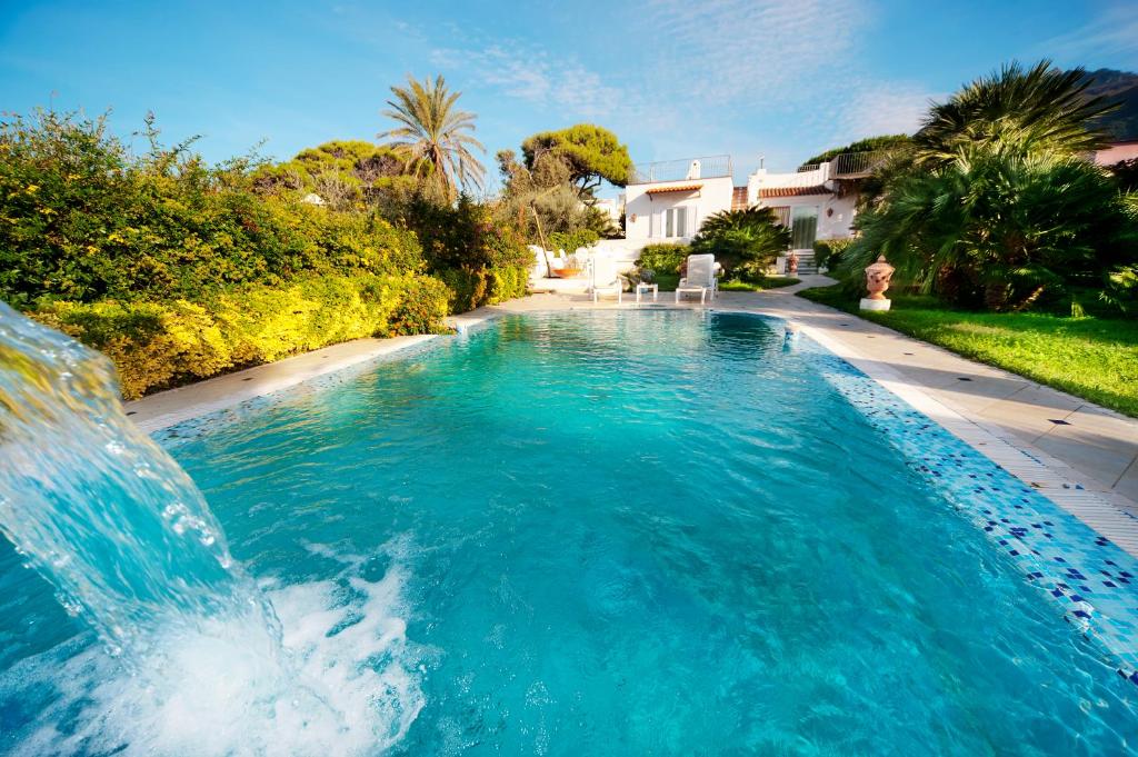 a swimming pool with a waterfall in a yard at Villa Formica in Ischia