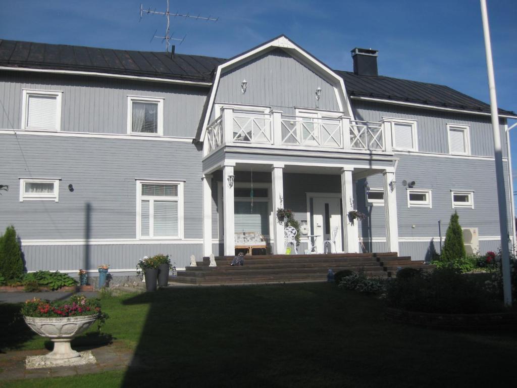 duży biały dom z werandą i tarasem w obiekcie Kotimajoitus Hella Härmä w mieście Kauhava