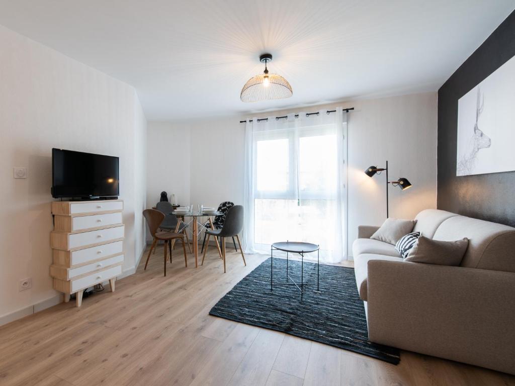 ein Wohnzimmer mit einem Sofa und einem Tisch in der Unterkunft Le Piccandet in Saint-Genis-les-Ollières