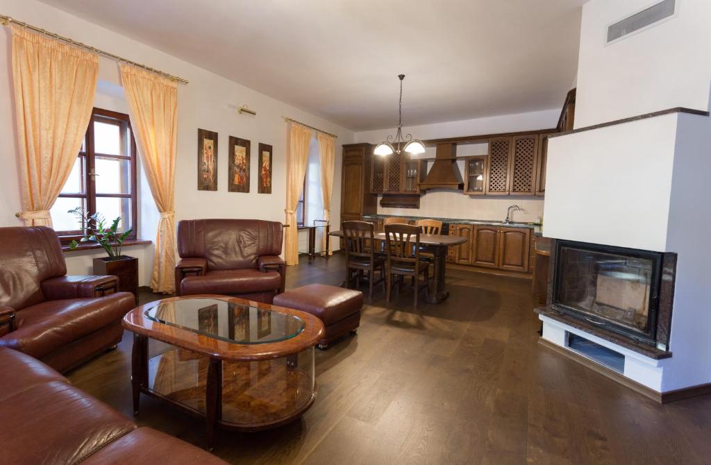 sala de estar con muebles de cuero y chimenea en Apartmán Pri Lýceu, en Banská Štiavnica