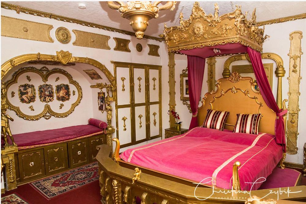 a bedroom with two beds with pink sheets and golditures at Königreich Romkerhall in Schulenberg im Oberharz