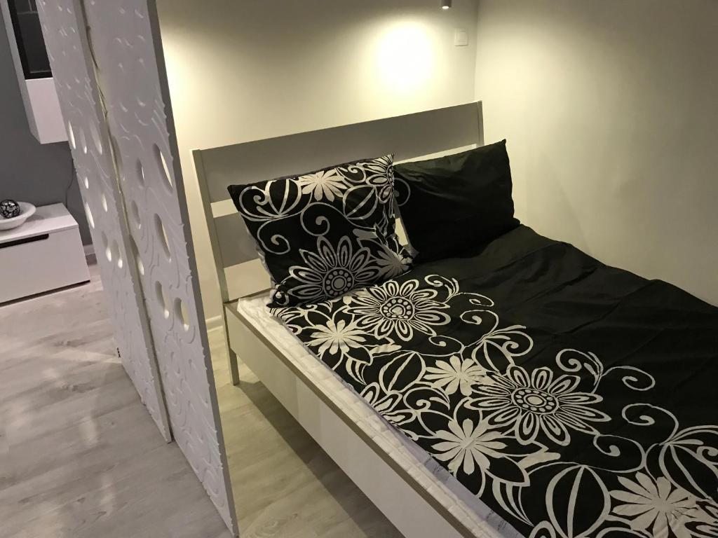 a bed with black and white pillows on it at Comfortable Apartament in Katowice