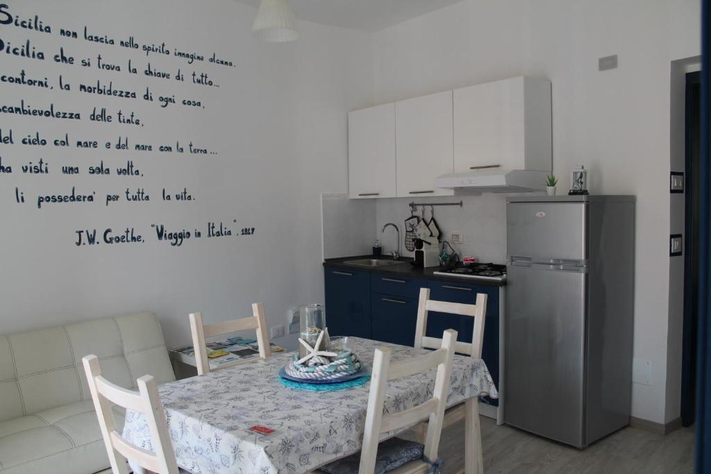 a kitchen with a table and a kitchen with writing on the wall at La casa del pescatore in Oliveri