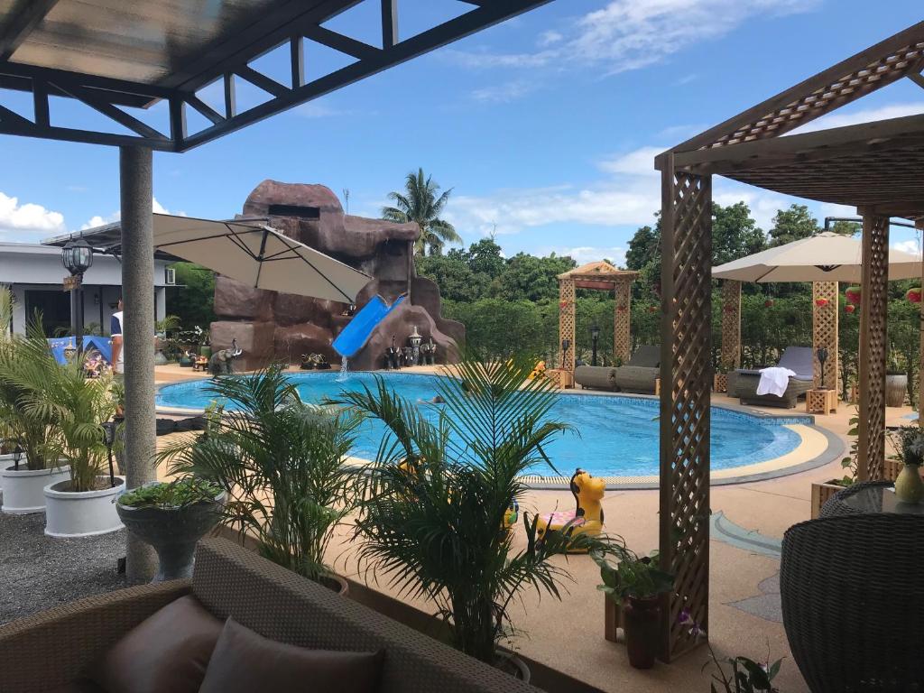 einen Pool in einem Resort mit einem Jungen auf einer Schaukel in der Unterkunft SB Holiday Resort in Chiang Mai