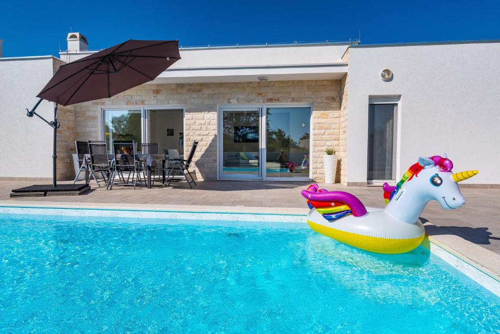 una piscina con un juguete de unicornio en una piscina en Holiday Home Gabriella, en Poljica