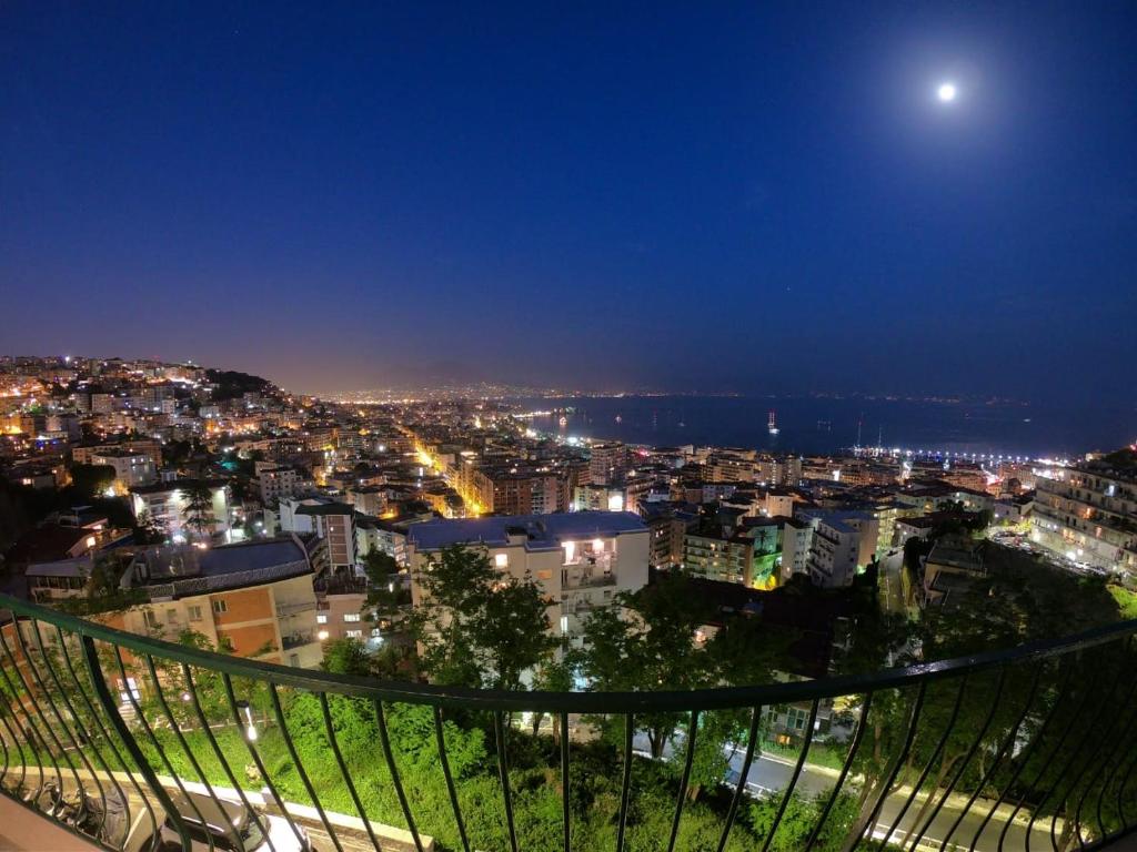 una vista de una ciudad por la noche con la luna en Nido Dei Gabbiani, en Nápoles