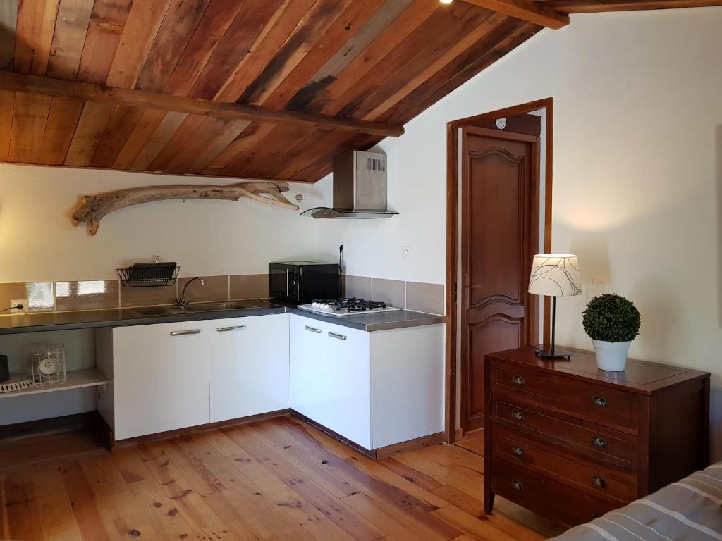 a kitchen with white cabinets and a wooden ceiling at Caseddu Di Poggiale in Figari
