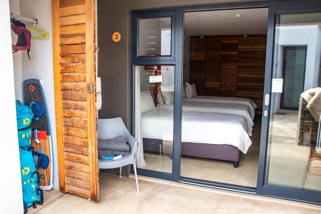Schlafzimmer mit einem Bett und einer Glasschiebetür in der Unterkunft Windtown Lagoon Hotel in Langebaan