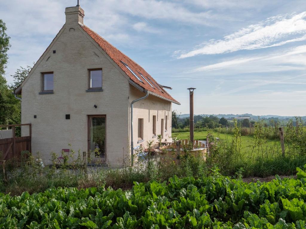 uma casa velha no meio de um jardim em Kompas gîte em Ellezelles